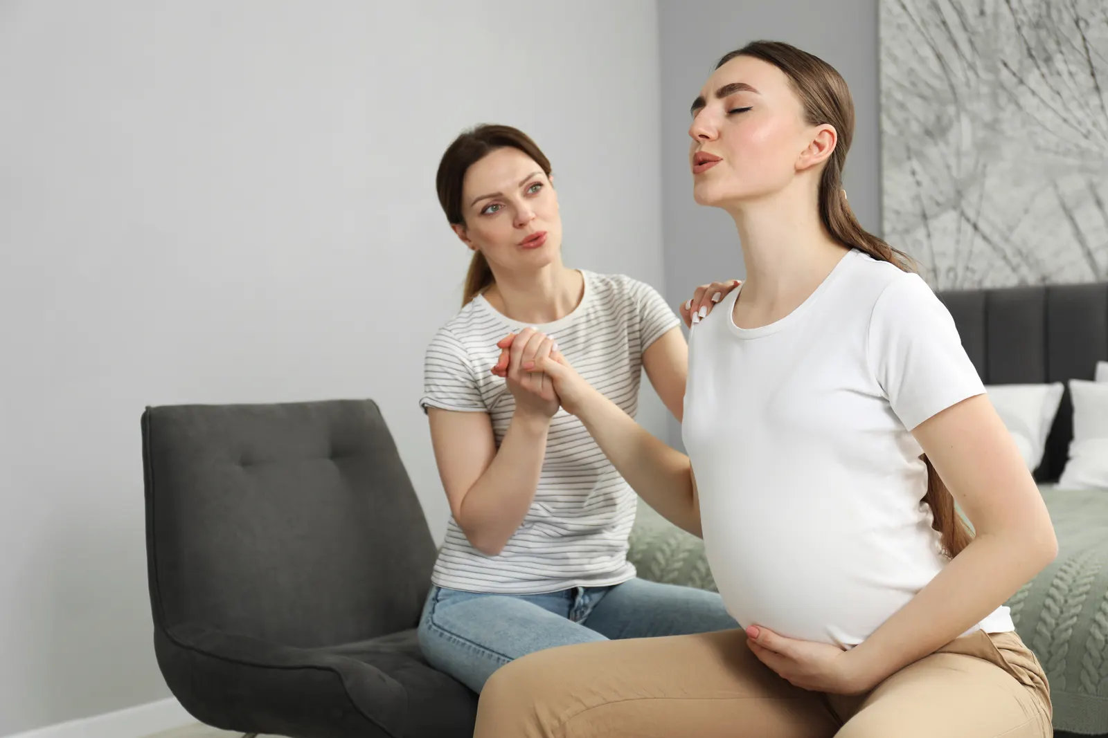 Doula pratiquant un massage des épaules sur une femme enceinte
