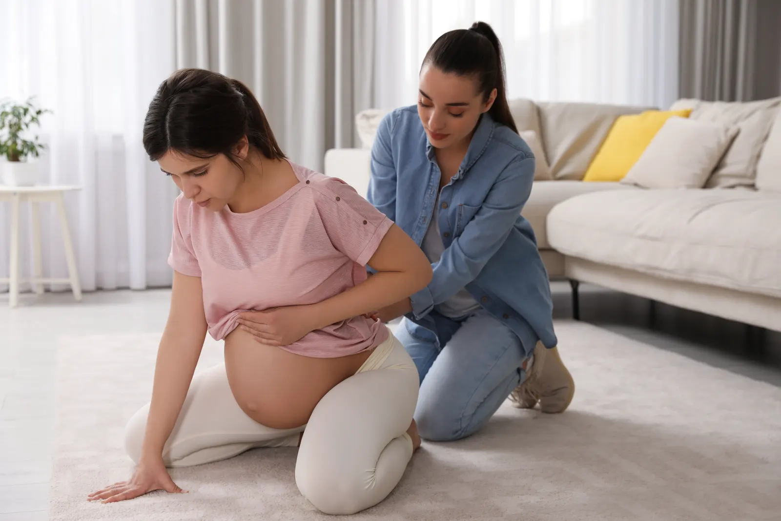 Doula exerçant un soutien lombaire sur une femme enceinte